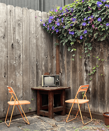 A back patio with two chairs and an old television
